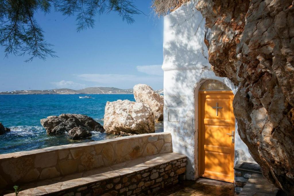 a door is open on the side of a building next to the ocean