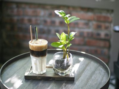 A stylish shot of Vietnamese coffee and a plant on a café table, capturing a modern and cozy atmosphere.